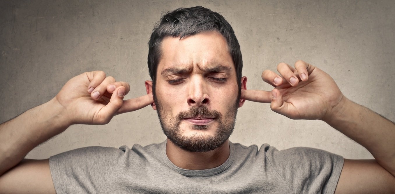 Click to enlarge man with fingers in ears