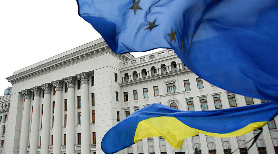 Ukrainian national (bottom) and EU flags fly outside the presidential administration building in Kiev