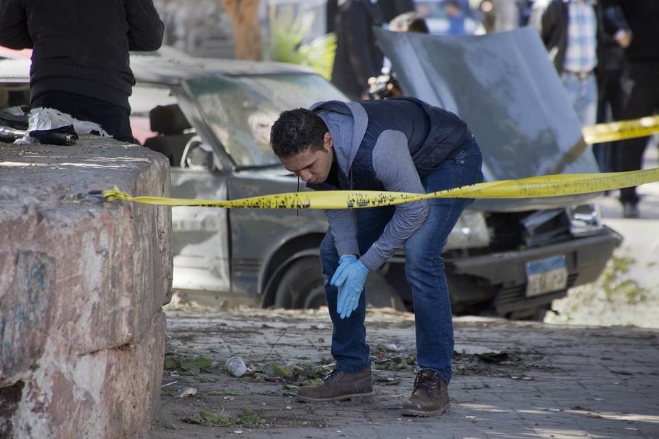 An explosives expert looks for evidence at the site of Friday’s bomb blast in Cairo