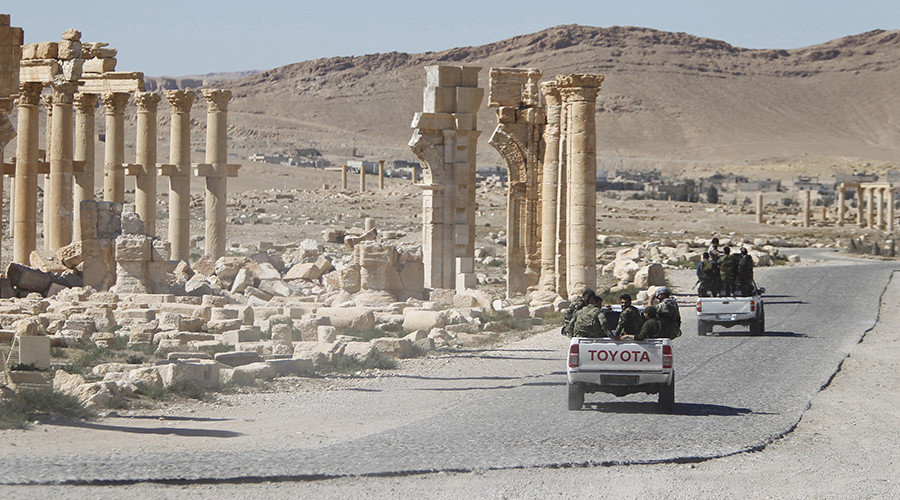 Click to enlarge Syrian army soldiers drive past the Arch of Triumph in the historic city of Palmyra