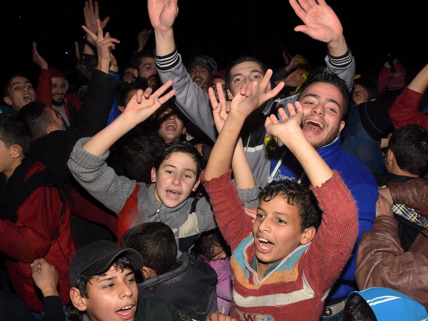 Click to enlarge Syrians celebrate in the government-held Mogambo neighbourhood of the northern Syrian city of Aleppo