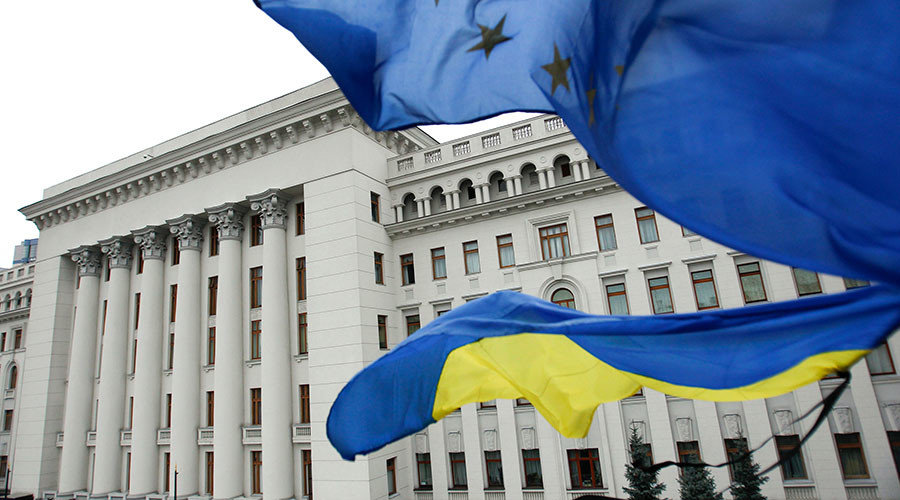 Ukrainian national (bottom) and EU flags fly outside the presidential administration building in Kiev