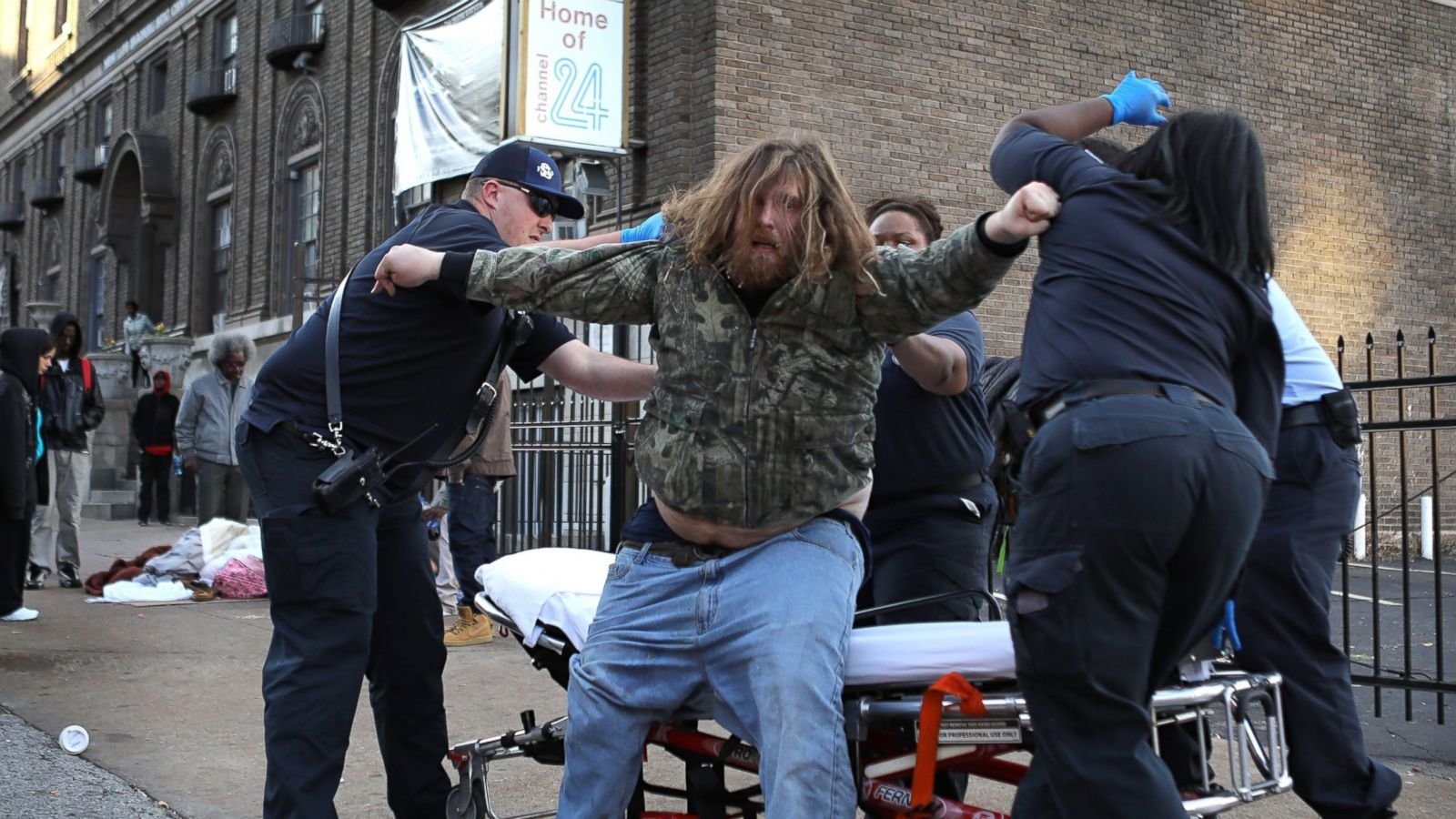 Medics helping homeless man to stretcher