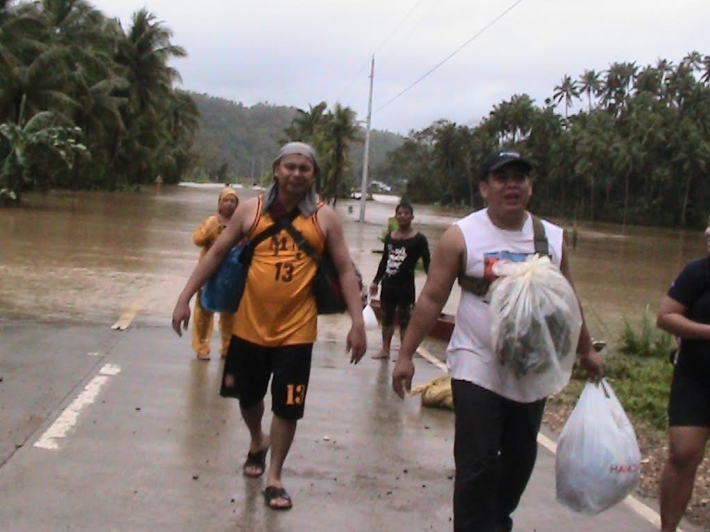 Click to enlarge People force themselves to walk on the highway in Eastern Samar after floods rendered the roads impassable.