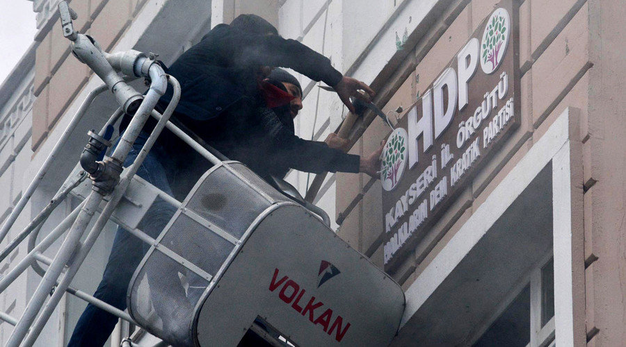 Protesters breaking and removing the logo on the facade of the offices of pro-Kurdish Peoples' Democratic Party