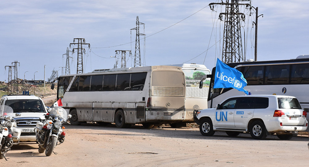 A vehicle from the UN drives through the Syrian government-controlled crossing of Ramoussa, on the southern outskirts of Aleppo, on December 18, 2016, during an evacuation operation of rebel fighters and civilians from rebel-held areas