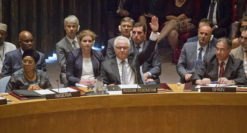 Russian UN Ambassador Vitaly Churkin, center, raises his hand to cast a vote to veto