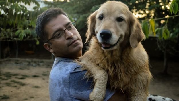 man carries dog