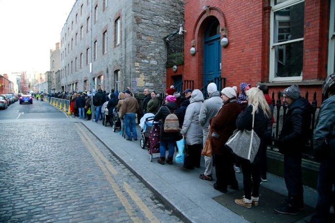  About 3,000 people, including elderly people and children, queue for Christmas food parcels at the Capuchin Centre in Dublin 