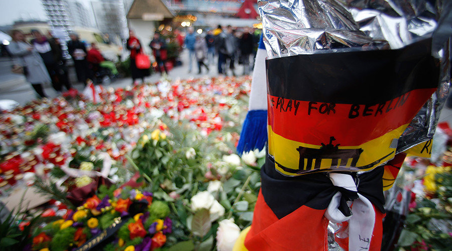 Click to enlarge Flowers and candles are placed near the Christmas market