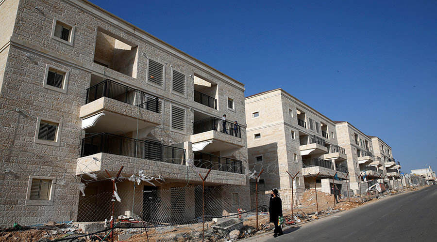 Jewish man walks past buildings under construction