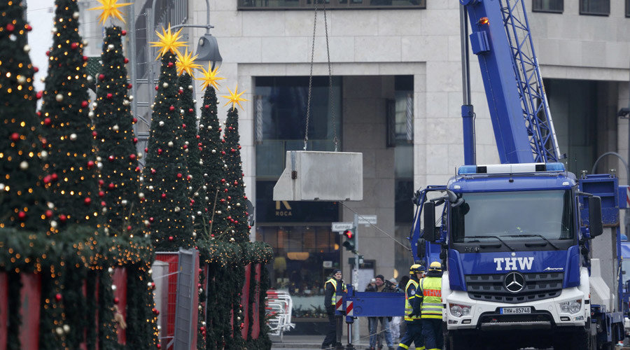 Workers place concrete barriers outside the Christmas market at Breitscheid square in Berlin
