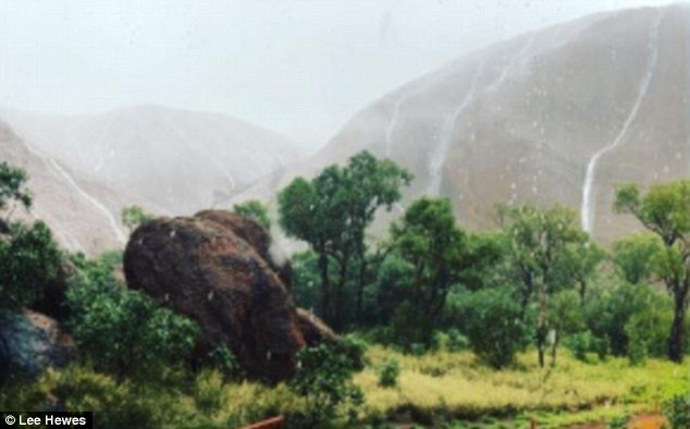 Rain hammers down on Uluru for the first time in months