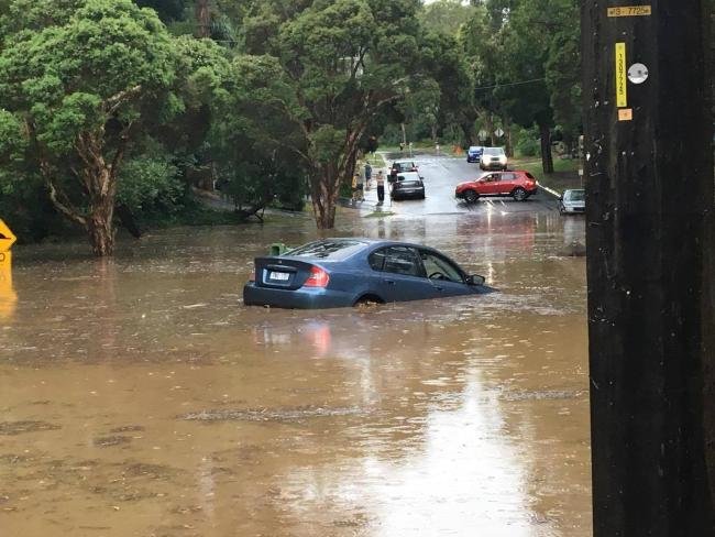 Click to enlarge A car submerged in floodwaters on the corner of Station St and McNicol Rd in Belgrave.