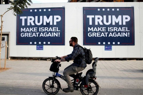 Man rides past Trump posters