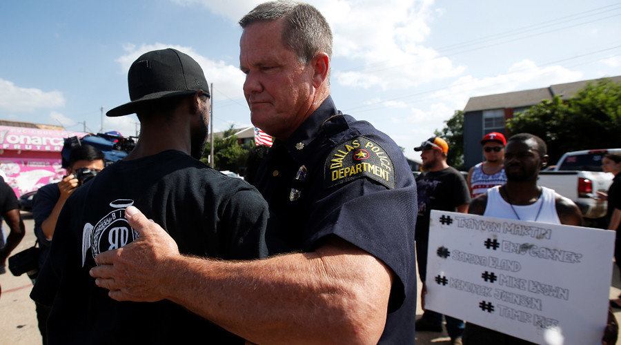Dallas police officer hugs a man