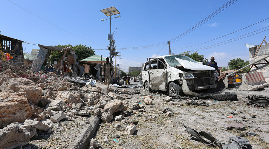 Click to enlarge Somali policemen look at the wreckage of a destroyed car at the scene of a suicide attack at a checkpoint outside the main base of an African Union peacekeeping force in the Somali capital Mogadishu, January 2, 2017
