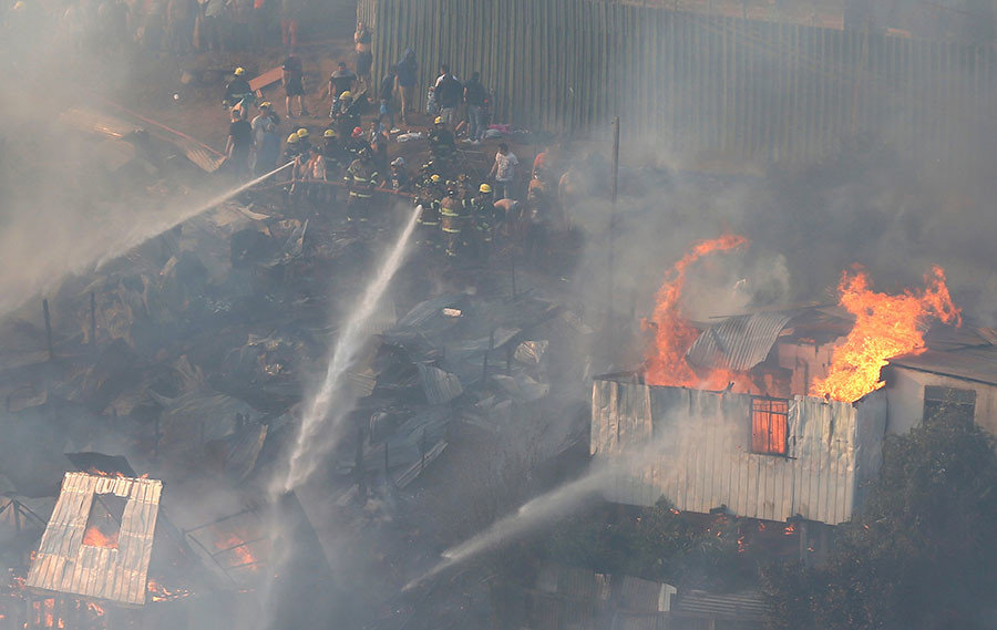 Click to enlarge Firefighters work to put out a fire in a house on a hill, where more than 100 homes were burned due to a forest fire but there have been no reports of death, local authorities said in Valparaiso, Chile January 2, 2017