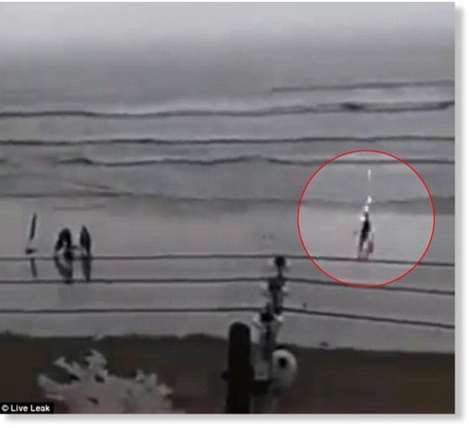 Video shows the woman walking down a rainy beach when lightning strikes