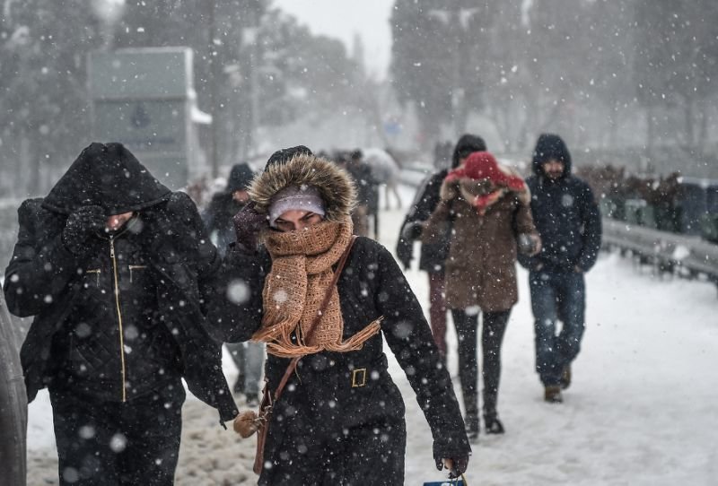 People walk during snowfalls in Istanbul on January 7, 2017 