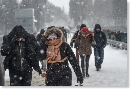 People walk during snowfalls in Istanbul on January 7, 2017 