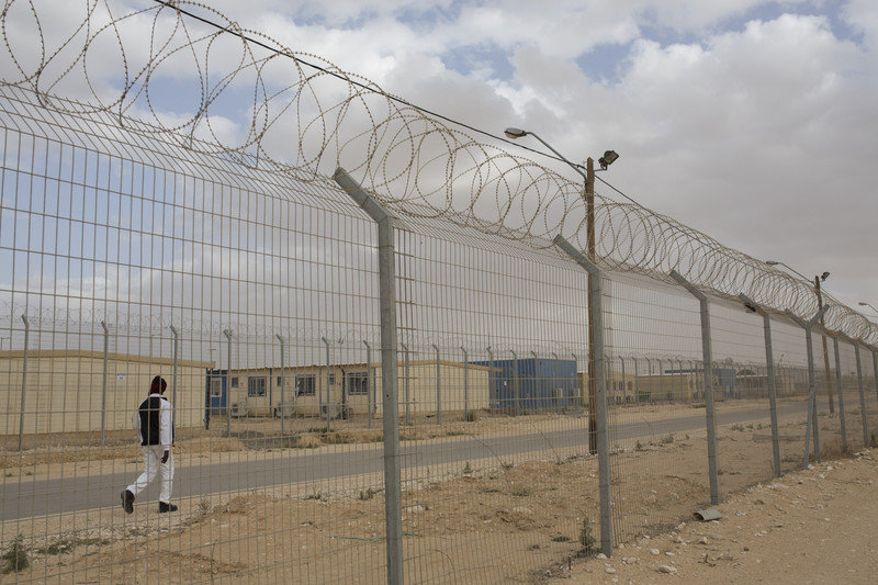 Click to enlarge African asylum seeker walks inside the Holot detention center