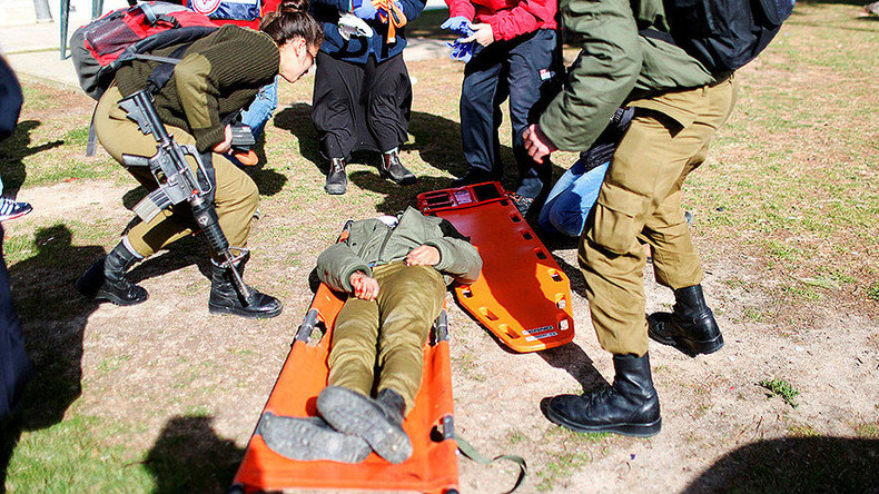 Israeli rescue forces and soldiers attend to an injured woman