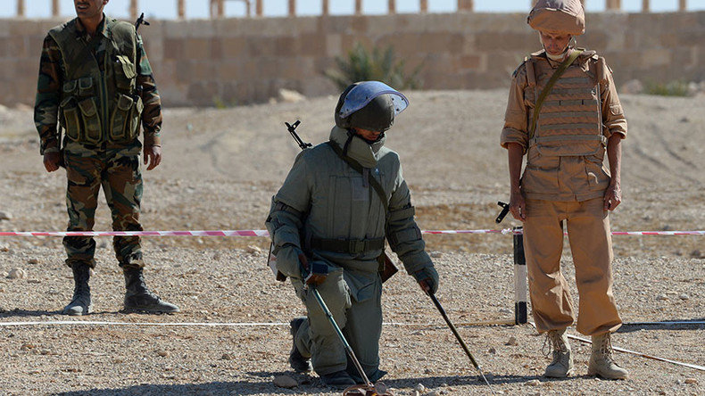 Russian serviceman, right, trains a Syrian soldier to search and detect explosive devices in Palmyra
