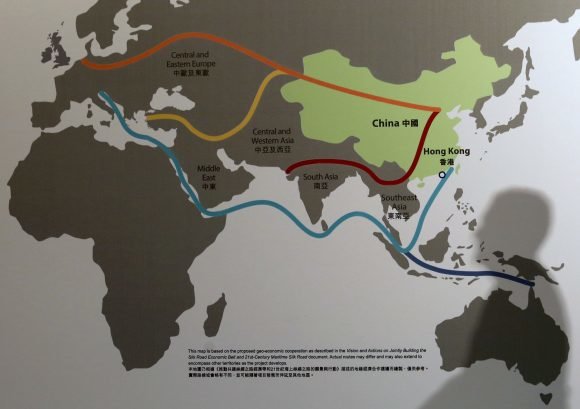  passerby casts a shadow over a map illustrating China’s “One Belt, One Road”