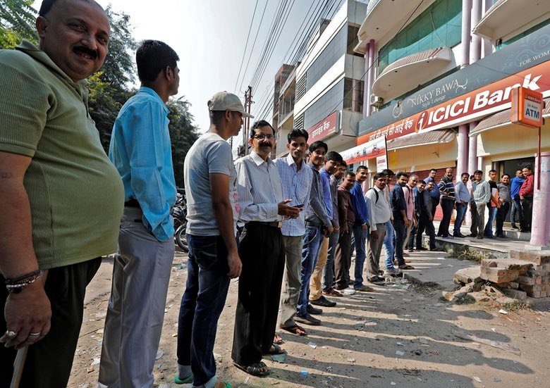 People queue to withdraw cash at a bank in Lucknow, India