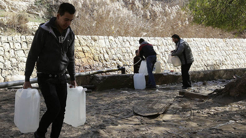 Syrians fill plastic containers with water