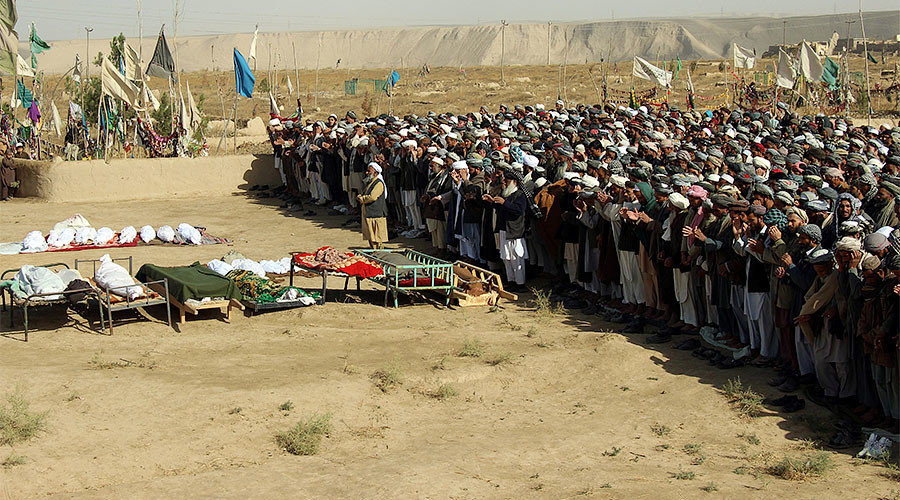 Afghans perform prayers at the funeral for the victims killed by an air strike