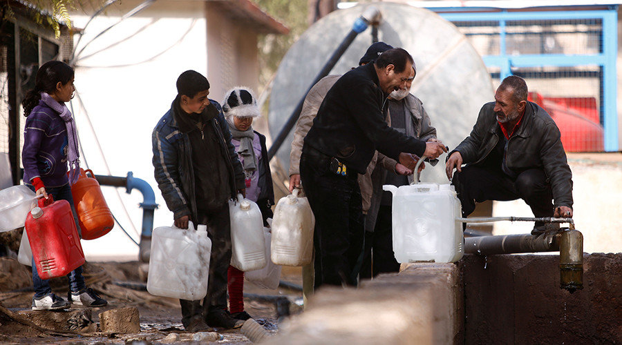 People queue as they fill containers with water