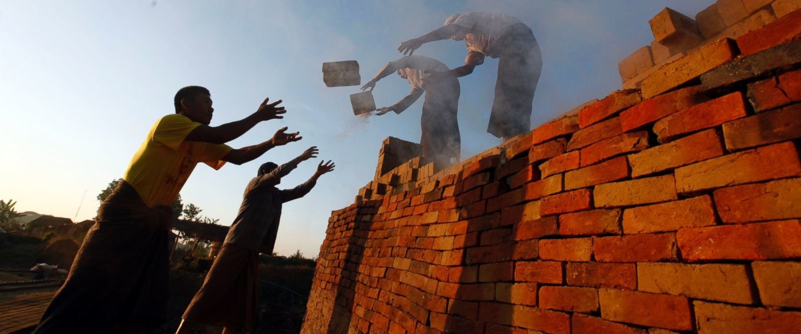 Workers unload bricks at a brick-making factory in Naypyitaw, Myanmar, Friday, Jan. 13, 2017. As bricks continue to be used in construction throughout Myanmar, traditional craftsmen who produce hand-made bricks are facing competition from machine-made bri