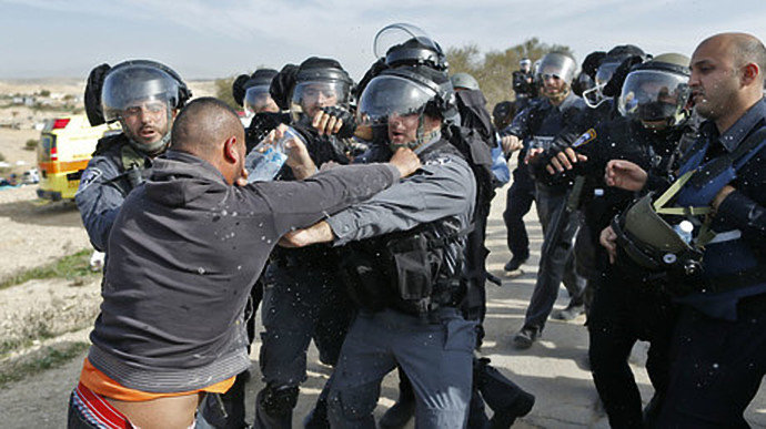 Israeli policemen clash a Bedouin man following a protest against home demolitions on January 18, 2017 in the Bedouin village of Umm al-Hiran, which is not recognized by the Israeli government, near the southern city of Beersheba, in the Negev desert