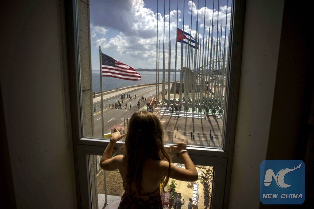 In this Aug. 14, 2015 file photo, a girl looks out from the newly opened U.S. Embassy after the U.S. flag raising ceremony in Havana, Cuba, as part of officially restored diplomatic relations