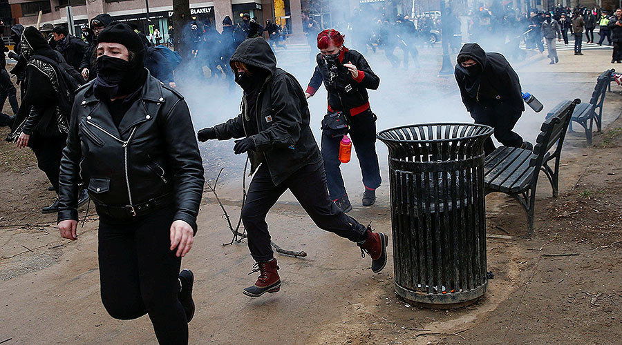 Click to enlarge Activists race after being hit by a stun grenade while protesting against U.S. President-elect Donald Trump