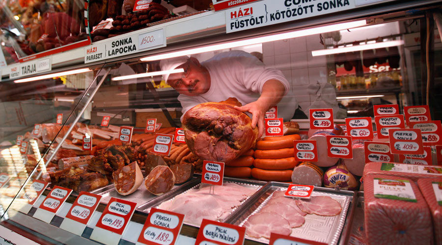 butcher arranges different cuts of meat in his shop in Budapest, Hungary