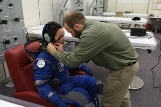 suit technician fits the communications carrier