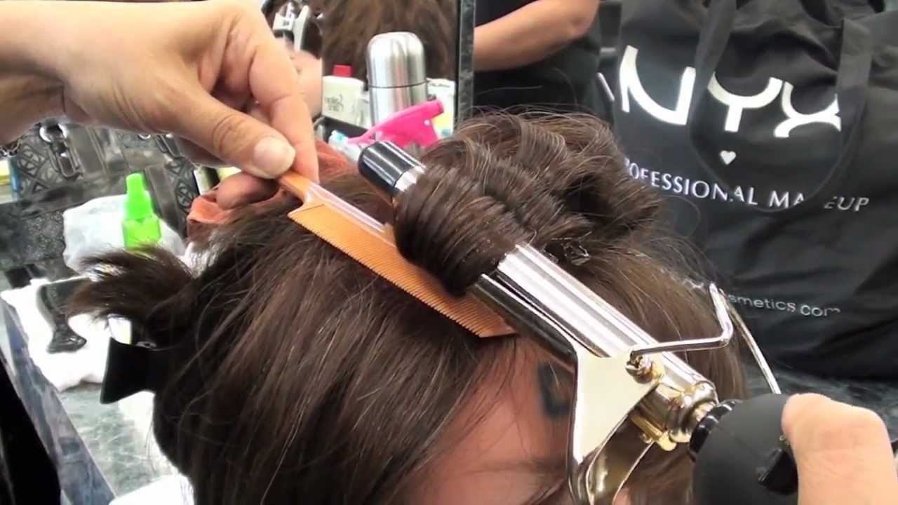 Cosmetologist with a hair curling iron
