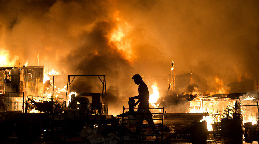 Residents look on as a fire destroys hundreds of houses Manila