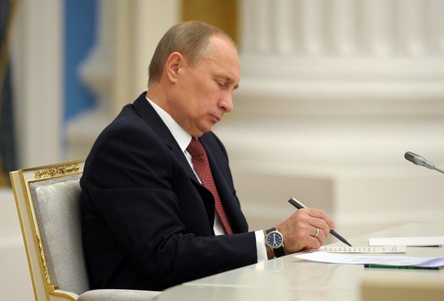 Vladimir Putin signing document