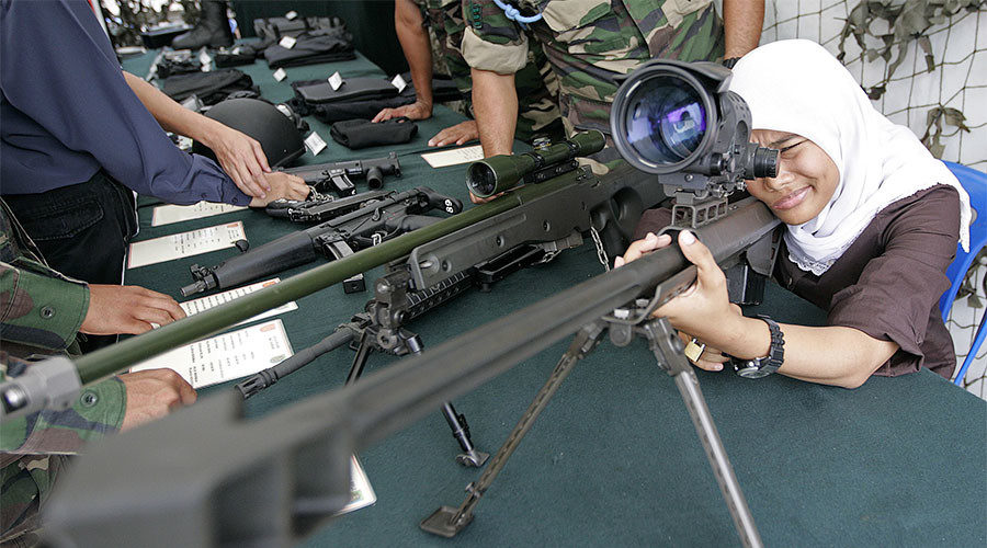 Woman inspecting large gun