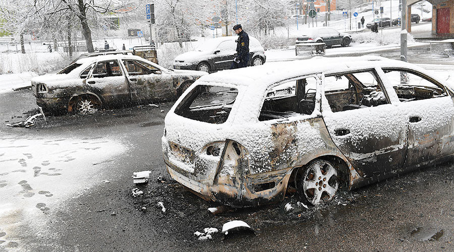 Click to enlarge policeman investigates a burnt car in the Rinkeby suburb outside Stockholm, Sweden