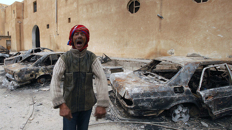 Click to enlarge A man gestures in front of burnt vehicles in a state security building in Tobruk, east of LibyaA man gestures in front of burnt vehicles in a state security building in Tobruk, east of Libya