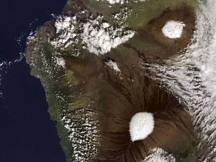 A NASA satellite captured snow on the Mauna Kea and Mauna Loa volcanoes on December 25, 2016 