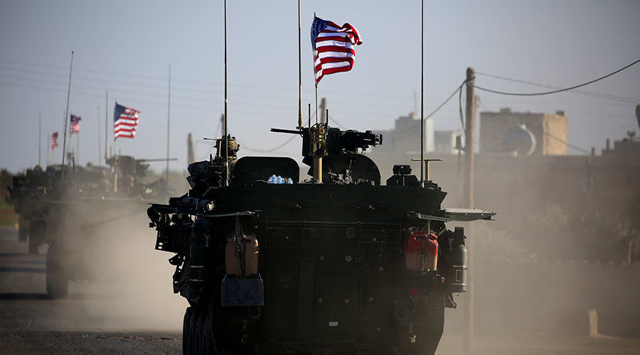 A convoy of US forces armoured vehicles drives near the Northern Syria