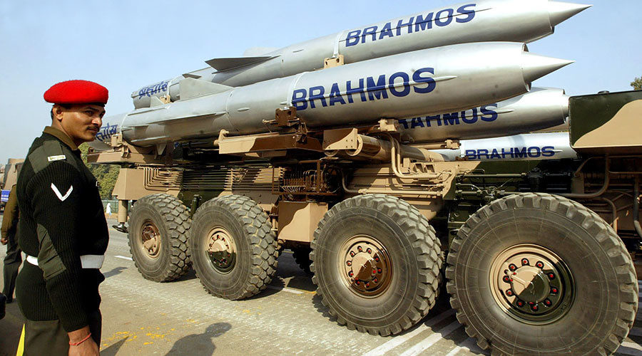 An Indian soldier stands guard near a truck mounted with Brahmos cruise missiles