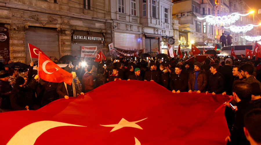 Click to enlarge People wave Turkish flags during a protest in front of the Dutch Consulate in Istanbul