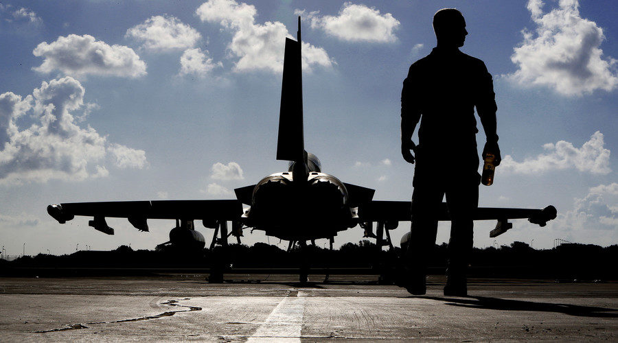 British soldier walks by a Royal Air Force Typhoon aircraft